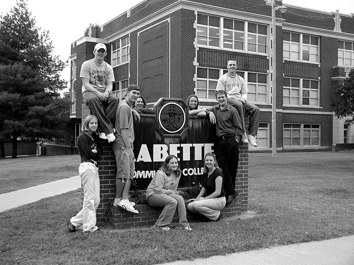 Students with Main Building Sign